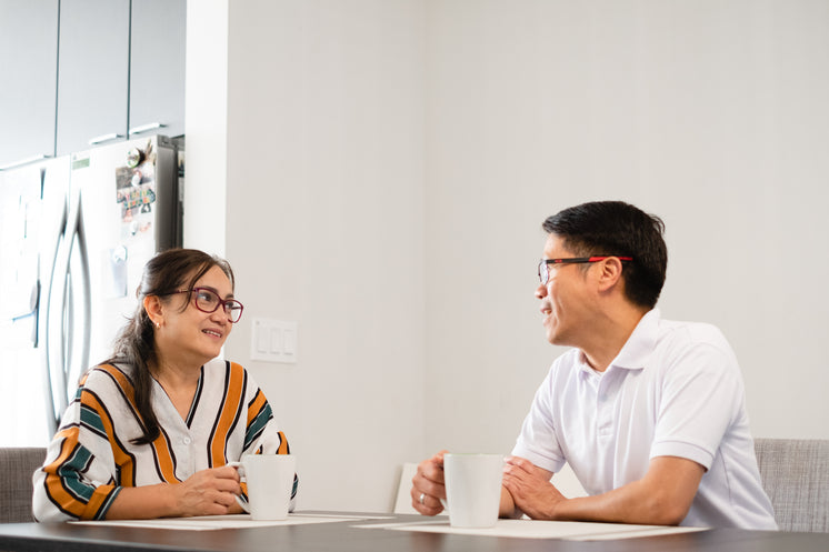 Two People Have Tea At The Kitchen Table