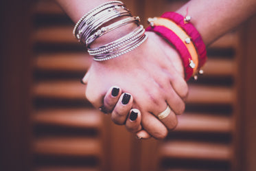 two people holding bangle-adorned hands