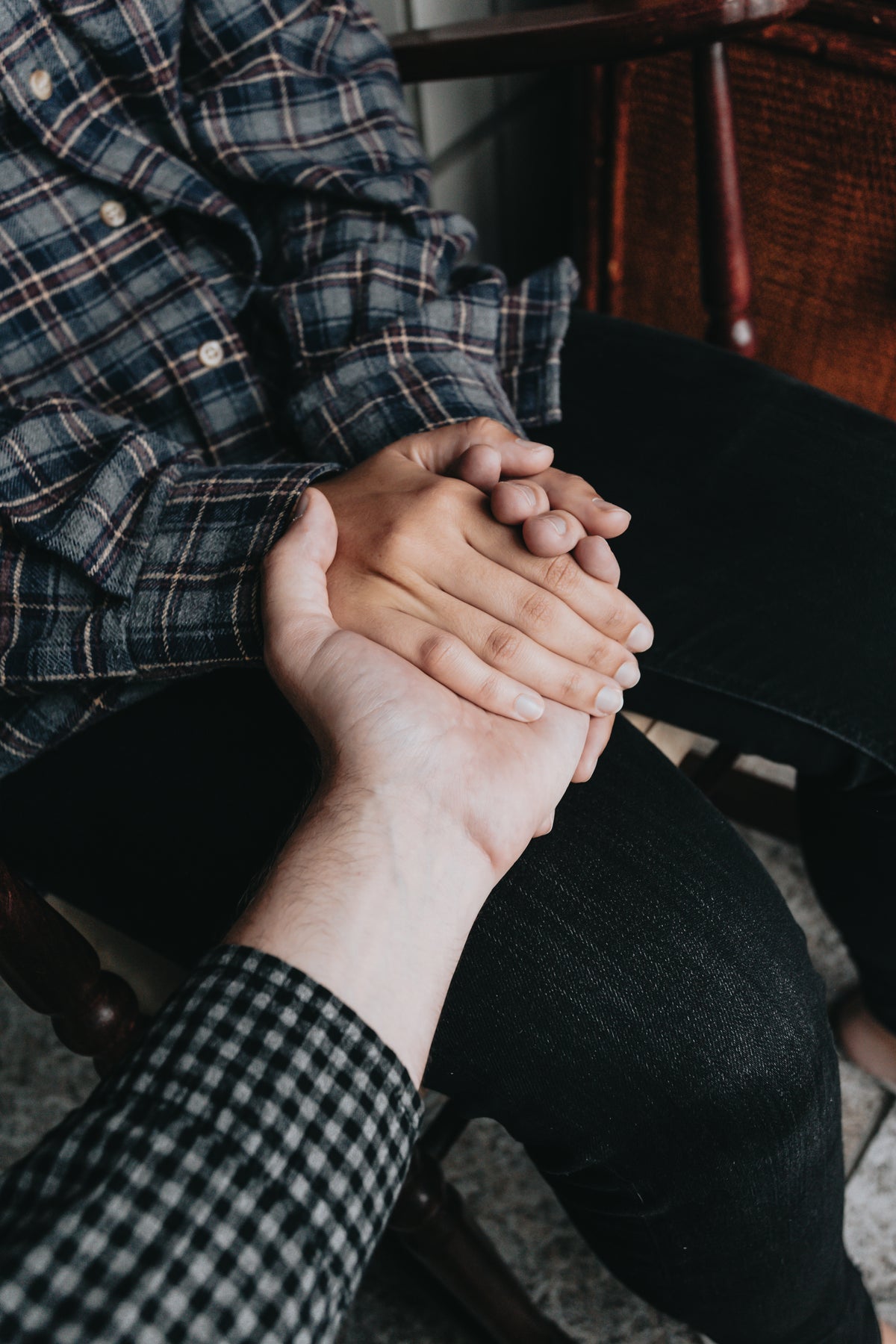 two people holding hands while sitting down