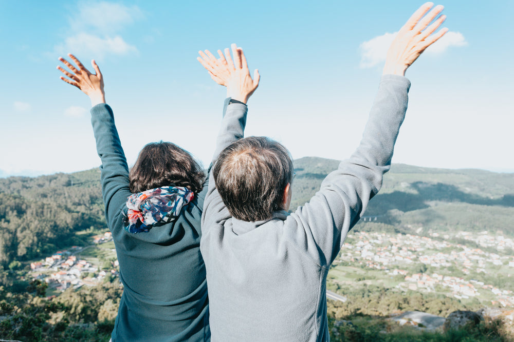 two people holds their hands above their heads