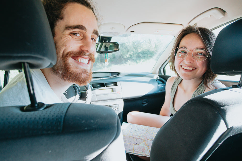 two people in a car looking back and smiling