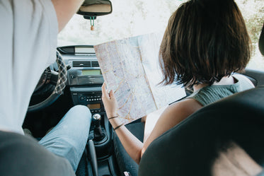 two people in a car with a large map held up