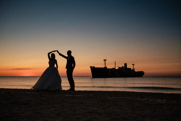 two people in formal wear dance on the beach