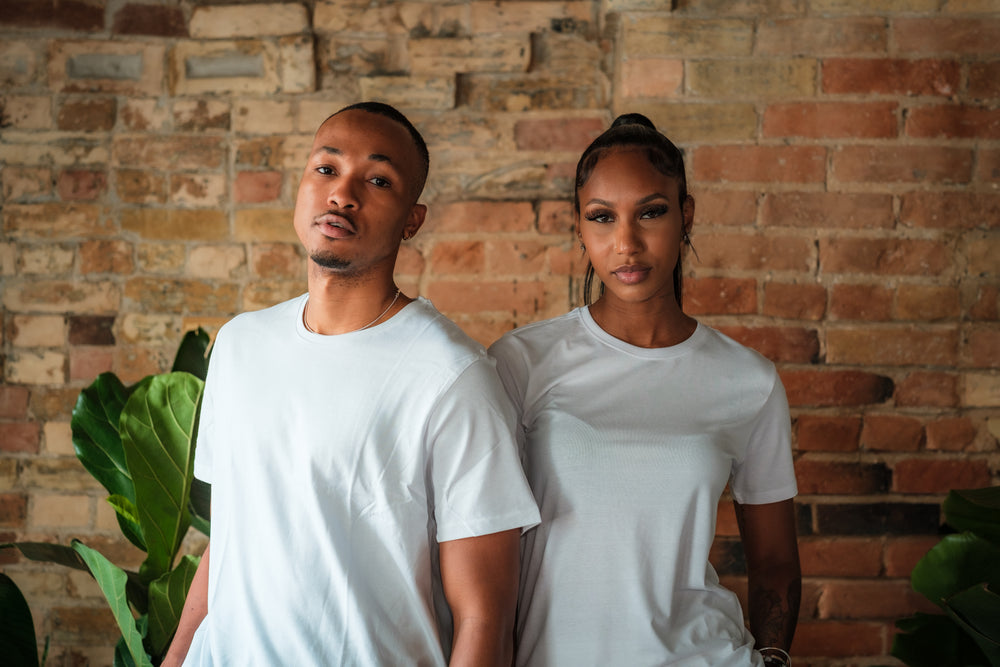 two people in white t shirts pose for the camera