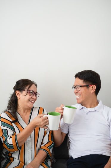 two people laugh as they look towards each other