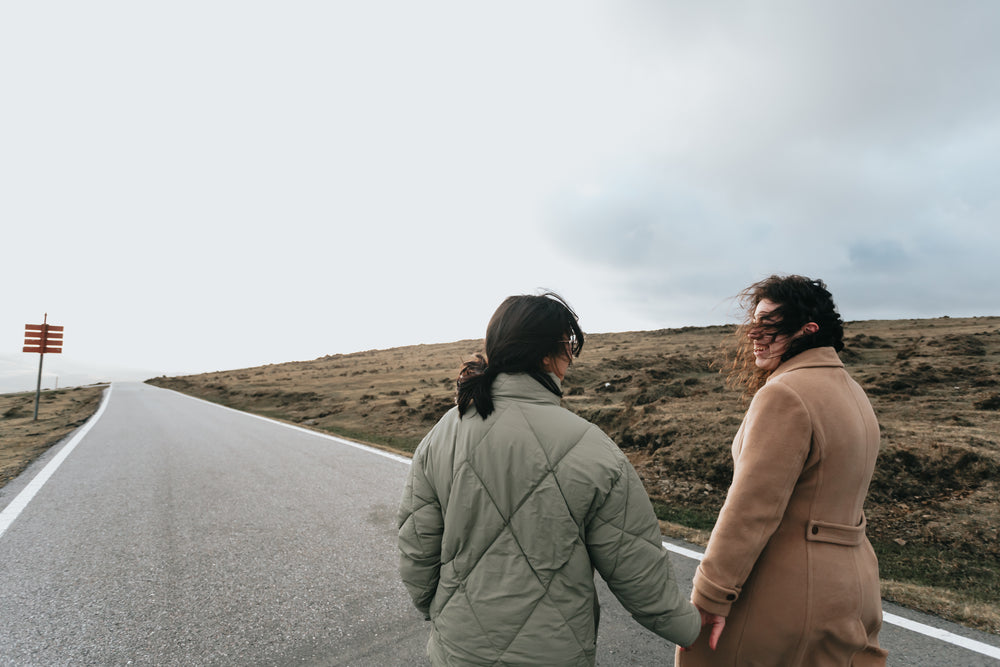 two people look at each other and hold hands outdoors