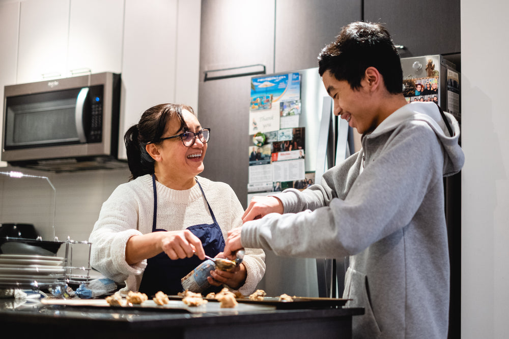 two people make cookies in there home kitchen