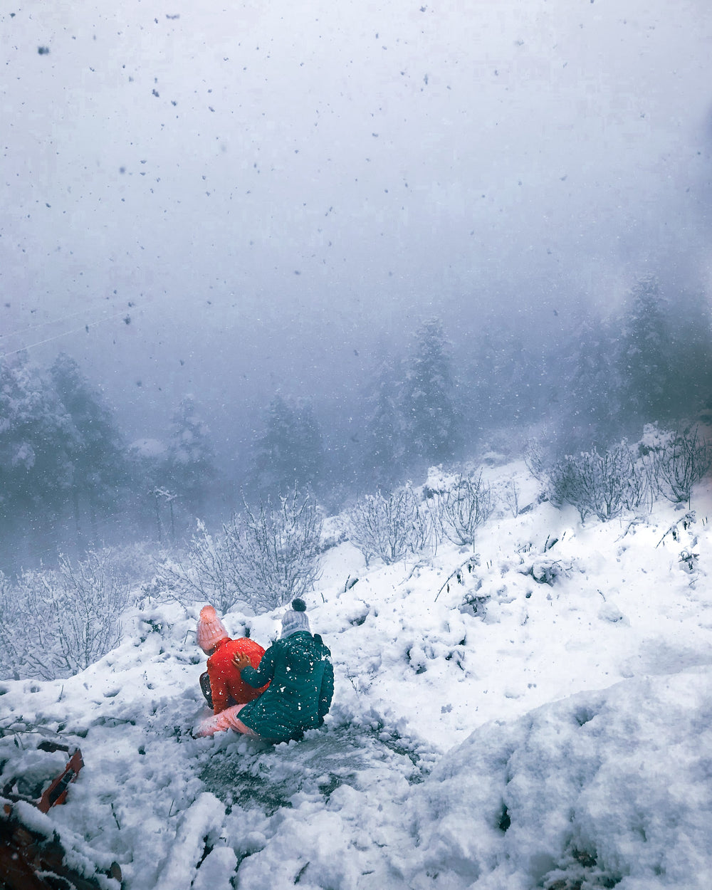 two people on a hill in a heavy snowfall