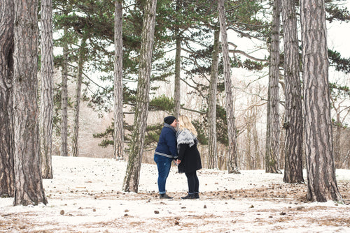 two people on a winter walk look lovingly at each other
