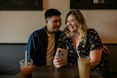 two people share a happy moment in a coffee shop