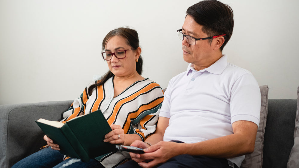 two people sit and look at a book