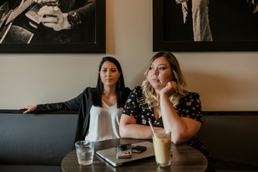 two people sit at a table in a cafe