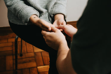 two people sitting across from each other and holding hands