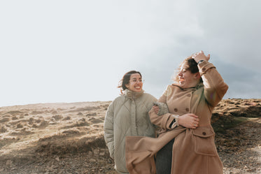 two people smile at each other while walking down a hill