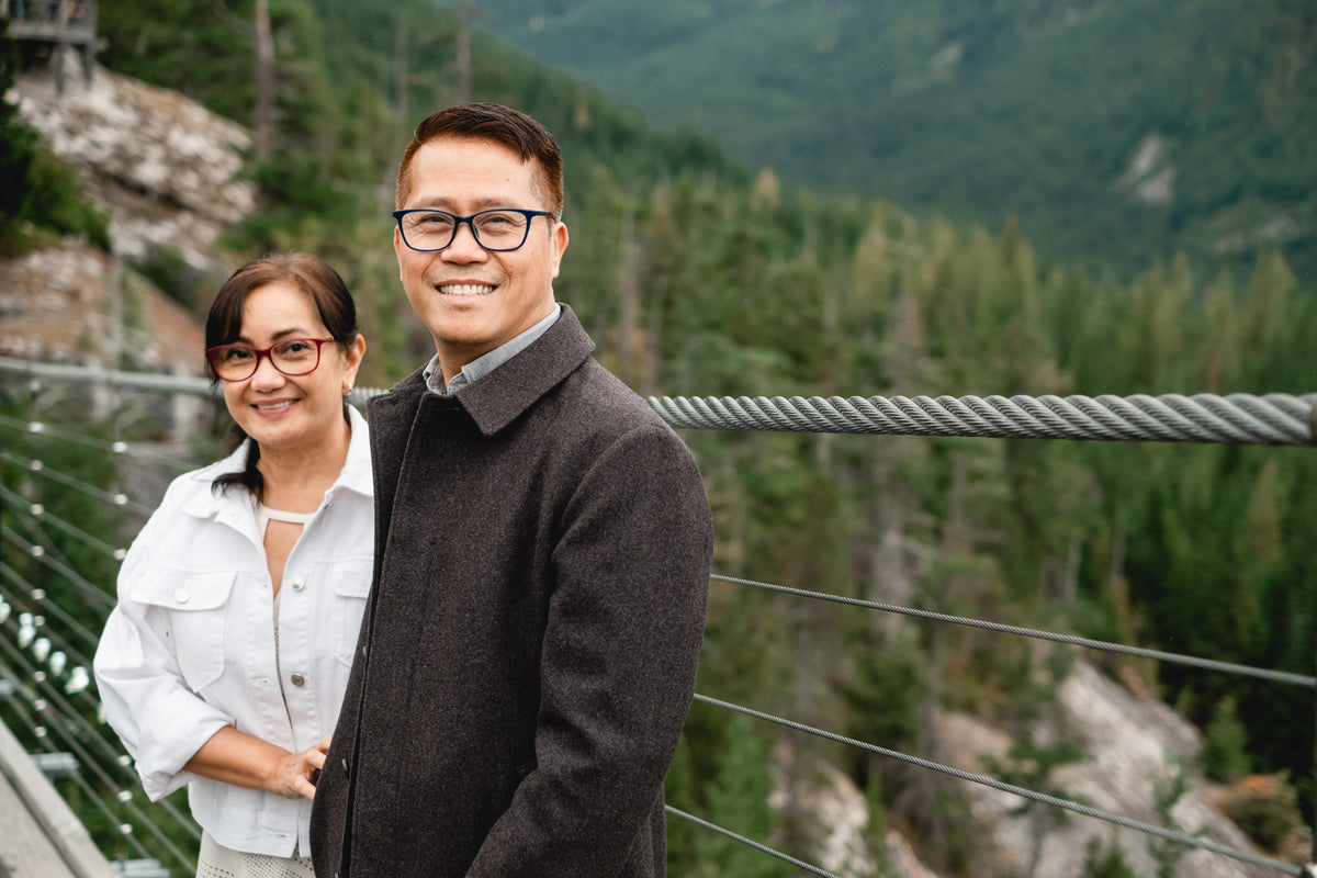 two people smiling while surrounded by dense forest