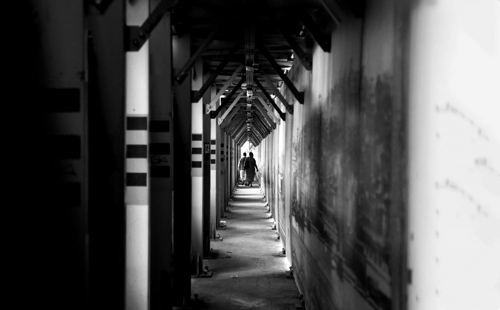 two people walk down a long hallway