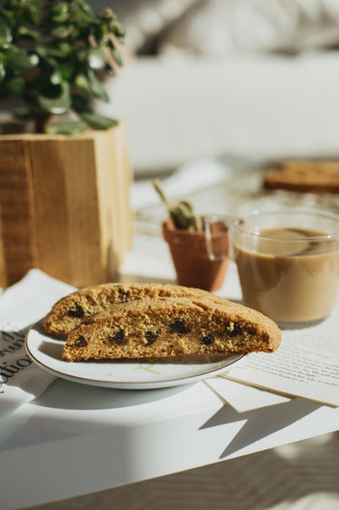 two pieces of biscotti next to a cup of coffee