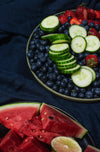 two plates on a linen tablecloth with summer fruit
