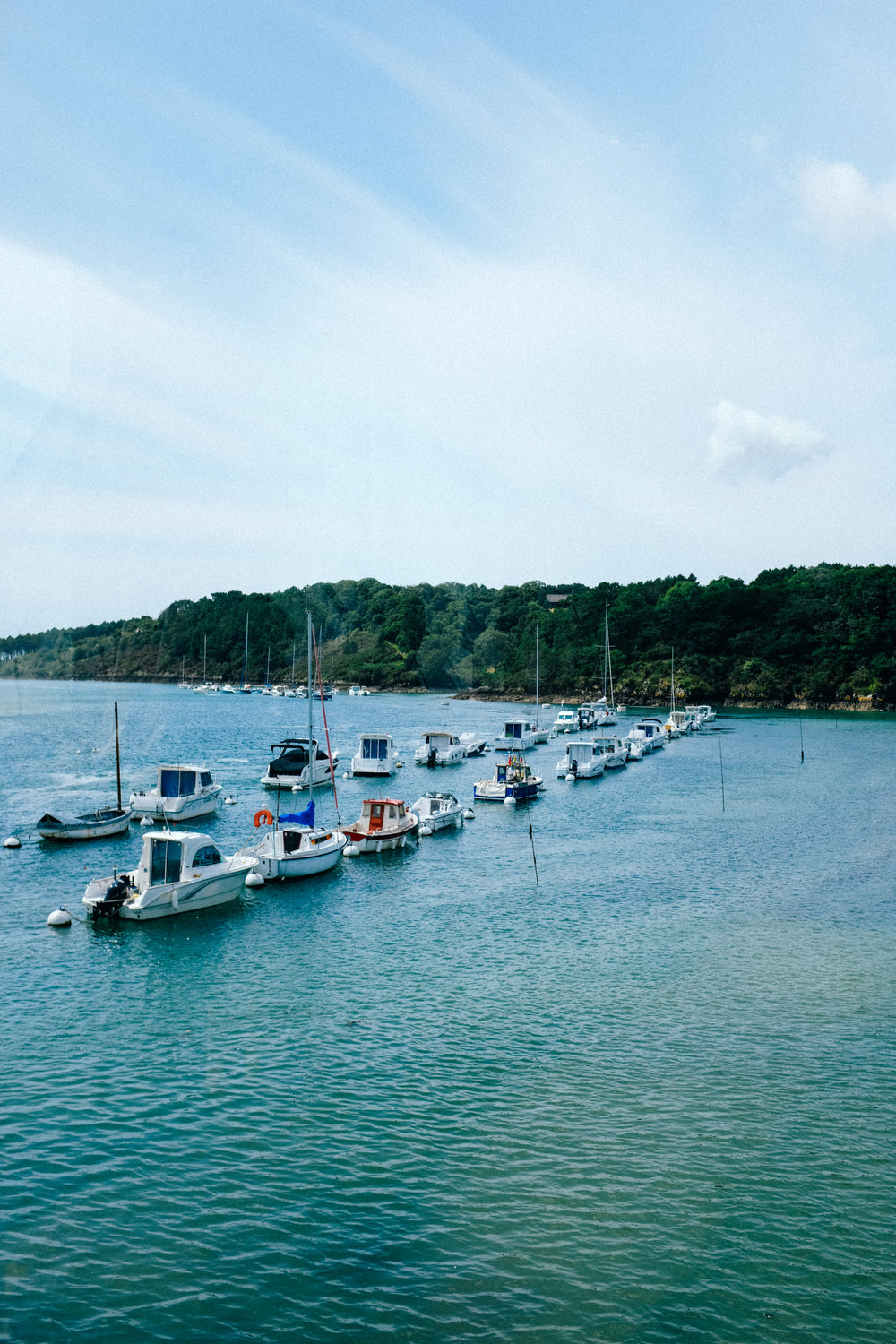 two rows of white boats in aqua blue water