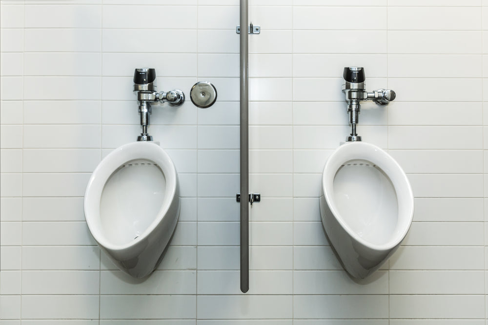 two urinals on white tile wall