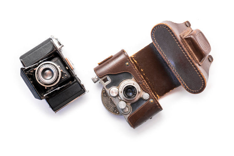 two-vintage-cameras-set-on-a-white-backg