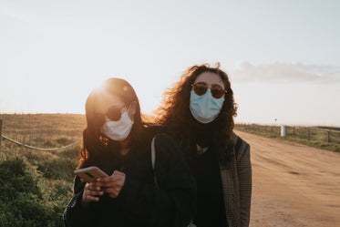 two woman in facemasks and sunglasses outdoors
