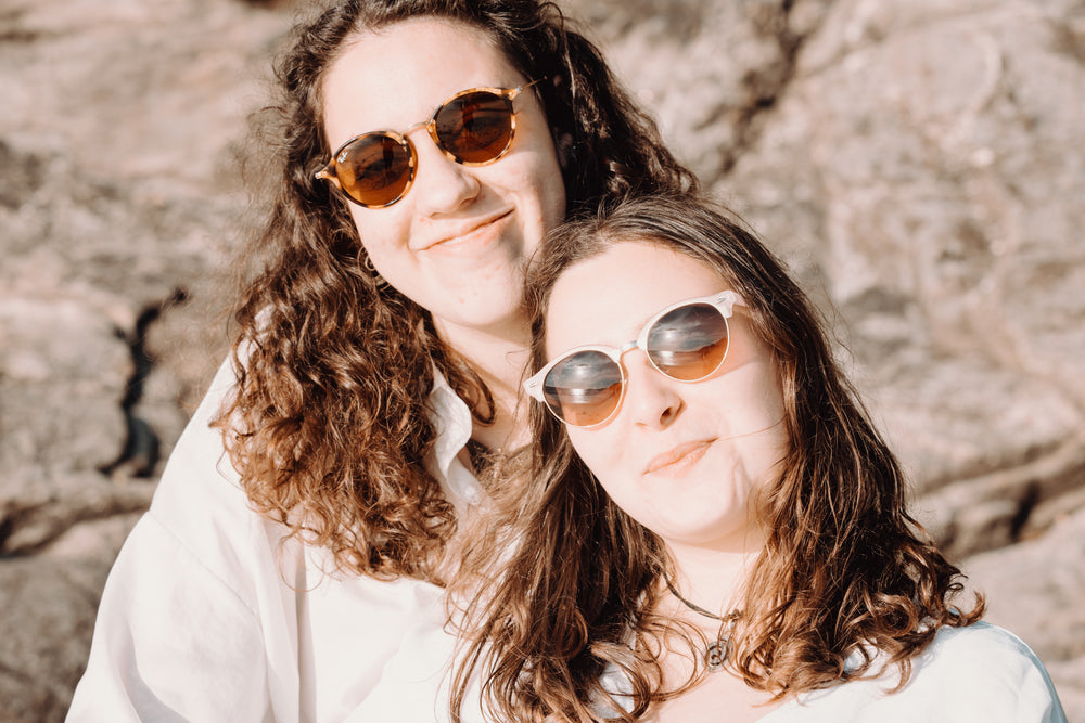 two woman in sunglasses smile for the camera