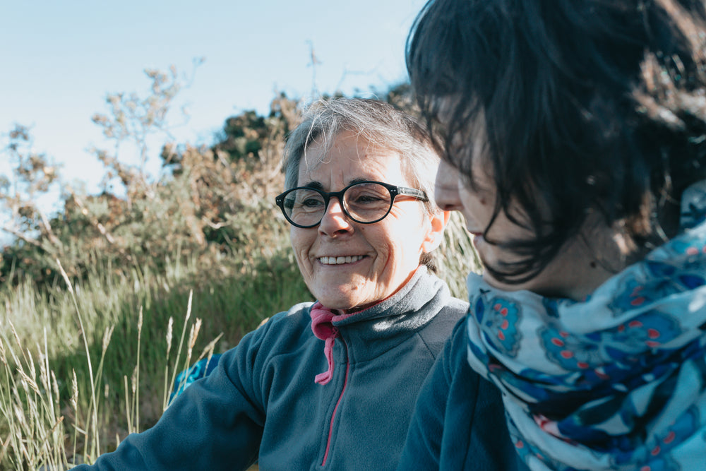 two woman outdoors with one woman smiling