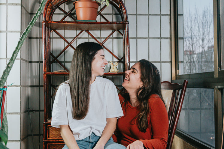 Two Woman Smile Wide As They Look At Each Other