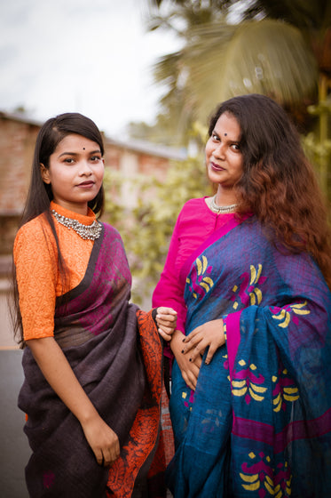 two woman stand outside and pose for the camera