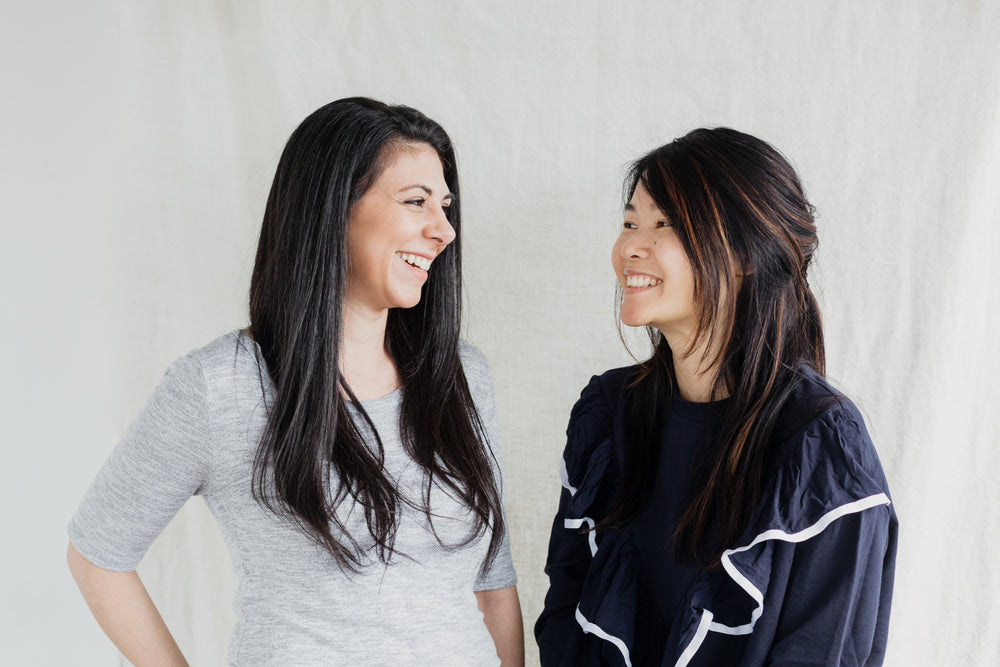 two women beam smiles at each other