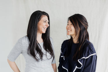 two women beam smiles at each other