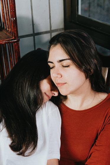 two women close their eyes and rest together