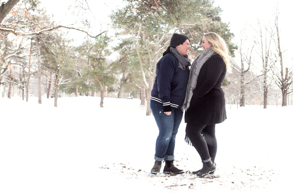 two women laugh in the snow