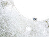 two women make snow angels in a snowy ball field