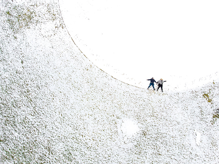 two-women-make-snow-angels-in-a-snowy-ba