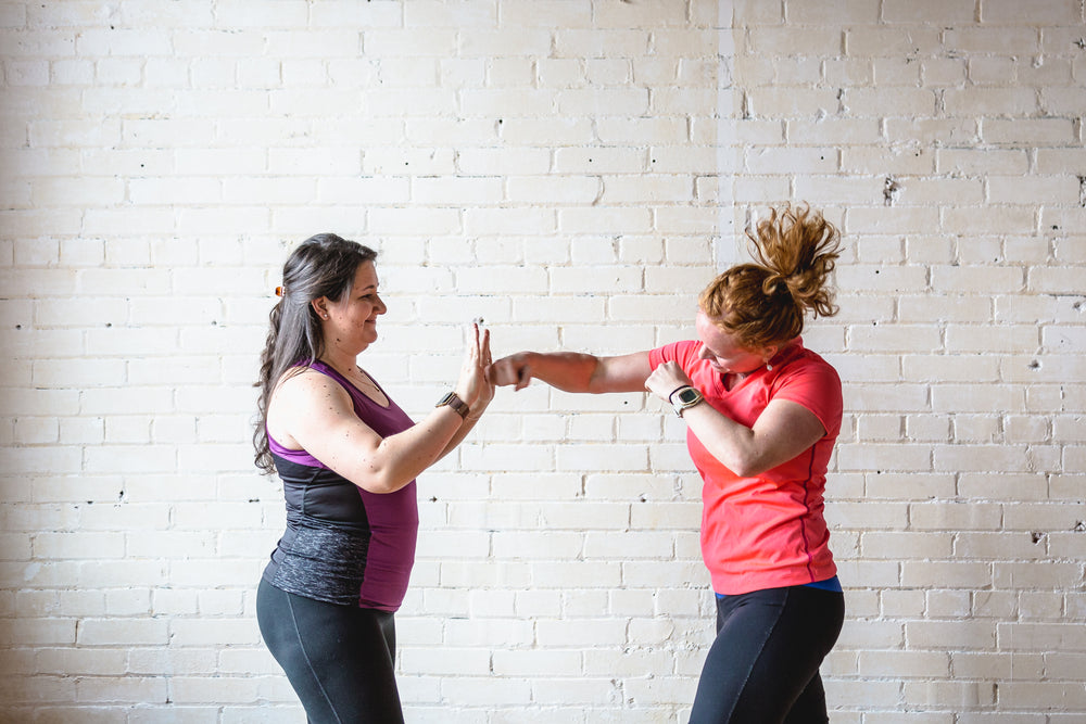 Woman doing boxing workout holding hand weights. Female doing shadow boxing  exercise against a wall. stock photo
