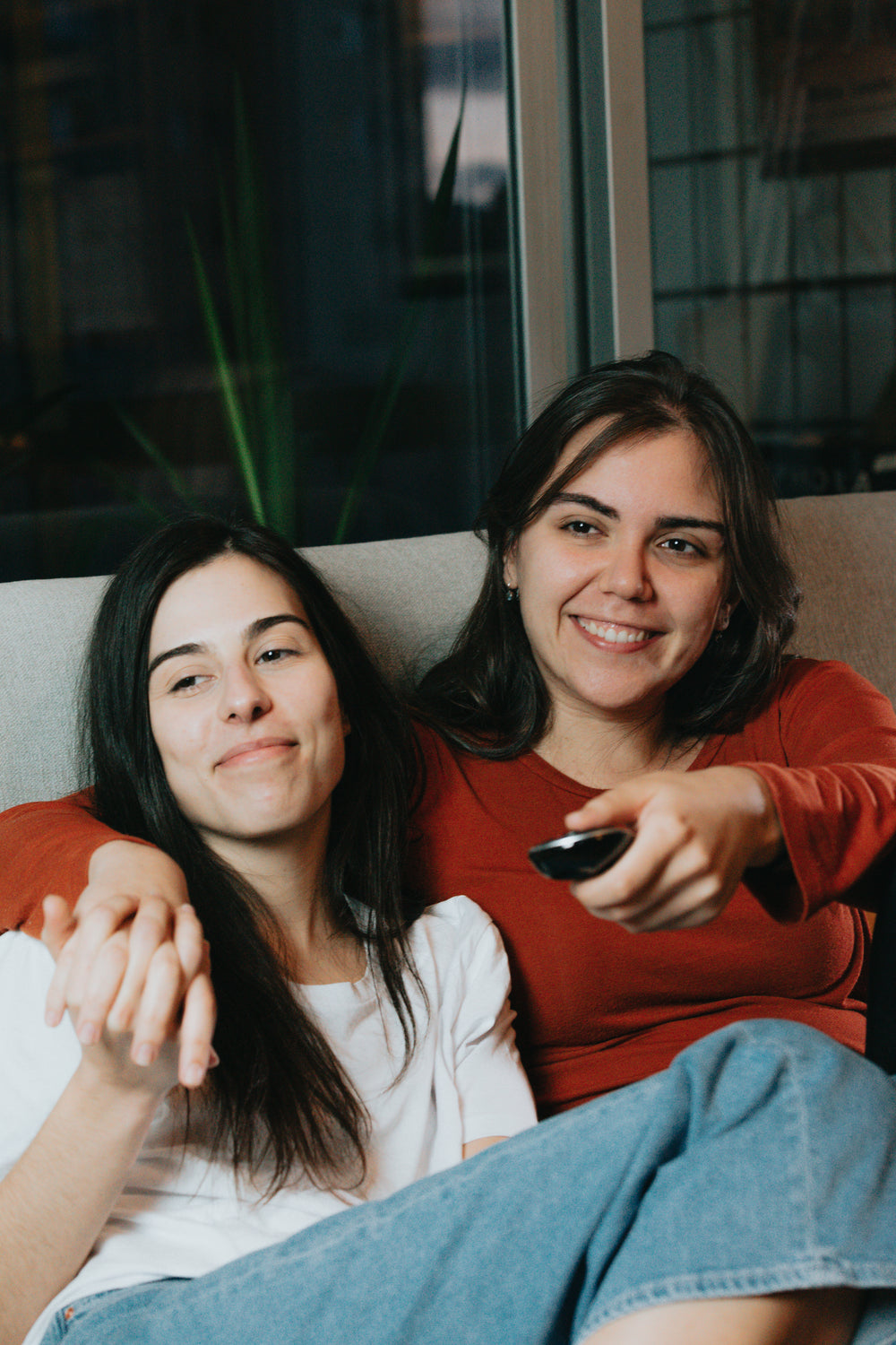 two women sit together in their living room