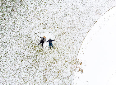 two women stretch out like stars in the snow