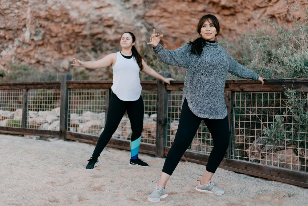 two women stretching on the beach