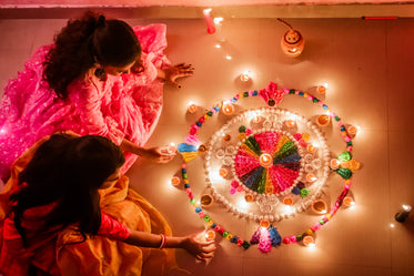 two young women arrange candles