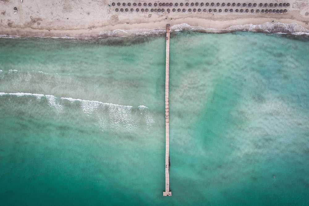 umbrella studded beach overlooking teal waters