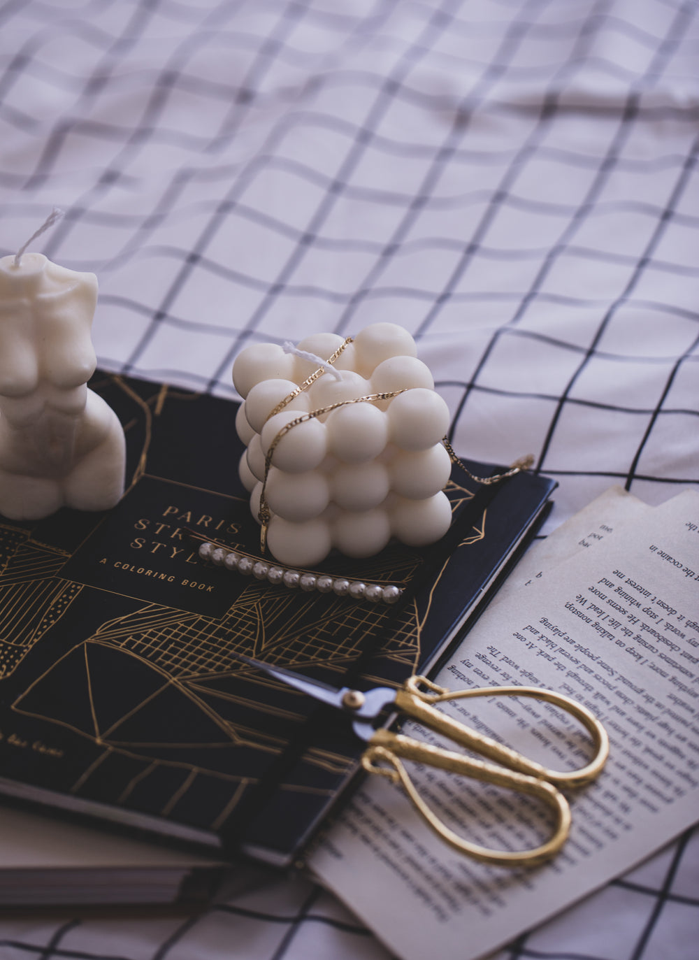 Unlit Candle On Book With A Draped Gold Necklace