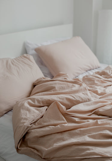 unmade dusty pink bedding
