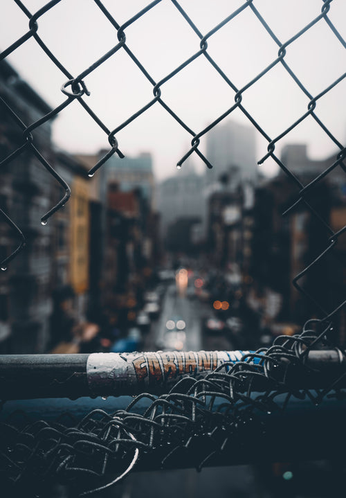 urban view through cut chain link fence