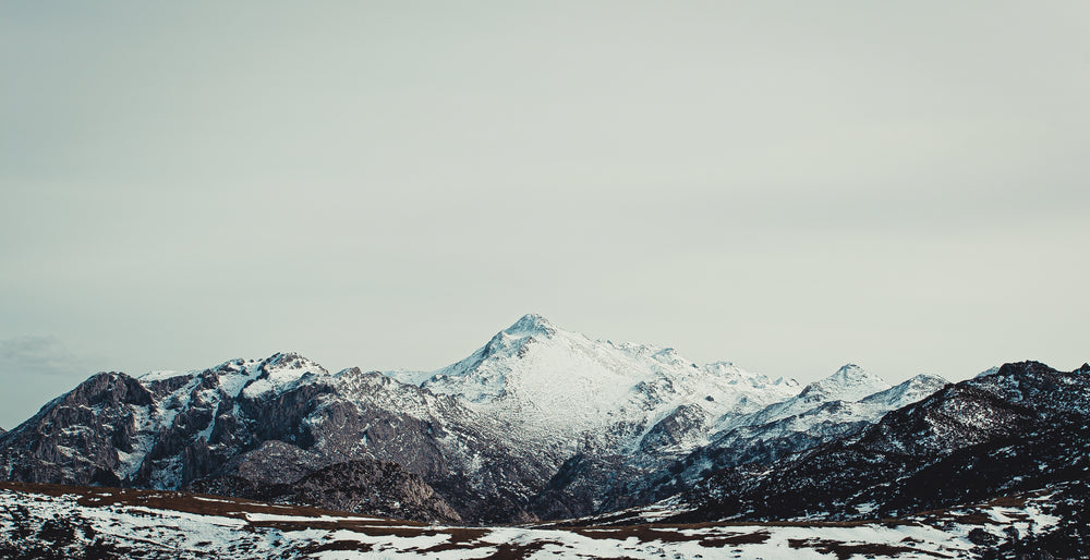 vast snowcapped mountain under grey sky