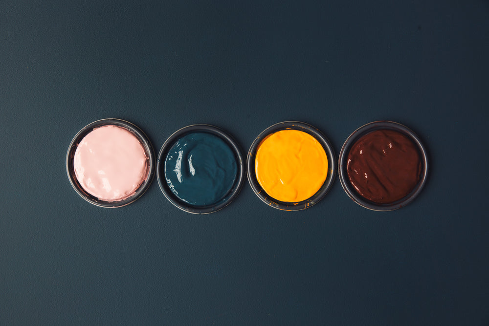 vibrant pots of paints on a blue table