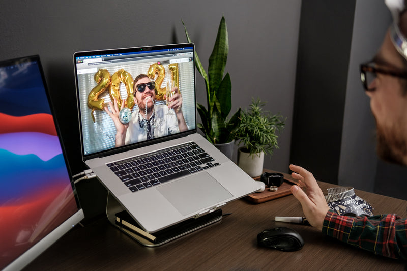 a man in a plaid shirt and a laptop computer - video call new years celebration