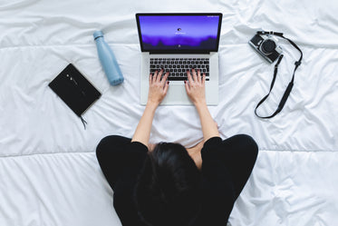 view from above of a person working on their laptop from bed