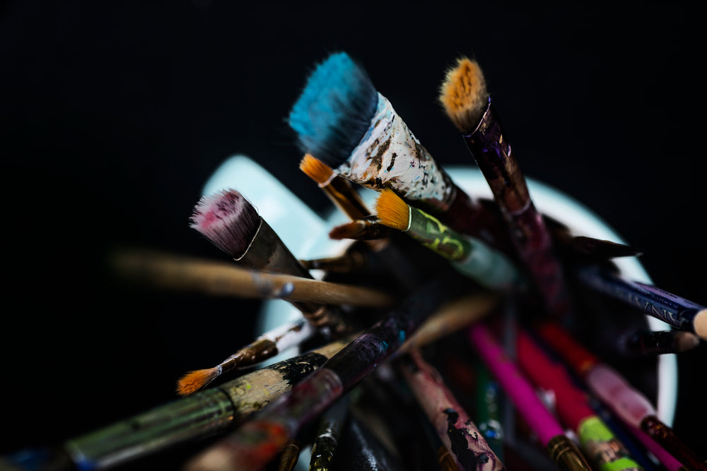 view looks down at a mug filled with paint brushes